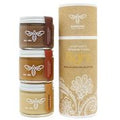 Three jars of honey with a decorative box on a white background